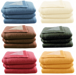 Image of L. plusieurs couvertures en laine dans différentes couleurs et textures, soulignant la qualité de cette matière naturelle.